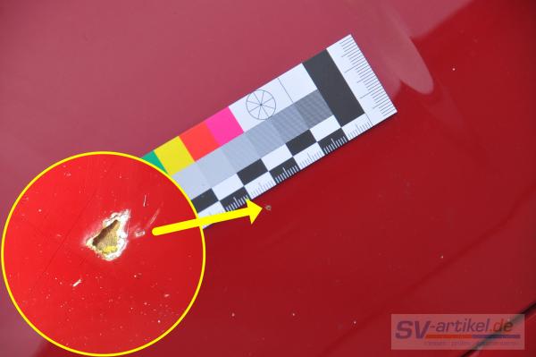 Steinschlag-Aufnahme von rotem Auto mit Beschriftung